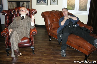 Sigmund Freud und Martin bei Madame Tussauds in Wien, in Österreich. Auf der linken Seite sitzt entspannt Sigmund Freud. Martin liegt auf der rechten Seite auf einer Couch mit weit geöffnetem Mund und hält sich mit beiden Händen krampfhaft den Hals.